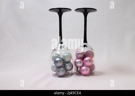 Rosa und graue Ornamente in Weingläsern. Hintergrund der Feiertage Stockfoto