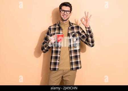 Foto von positiven Kerl Manager entspannen Kaffeepause machen okay Hand Symbol isoliert Pastellfarbe Hintergrund Stockfoto