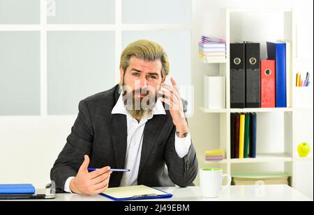 Krisenkonzept. Schadenverhütungsplan Wirtschaftskrise. Börsen- und Konjunkturzyklen. Mann bärtig Manager formell Anzug sitzen Büro. Investitionen Stockfoto