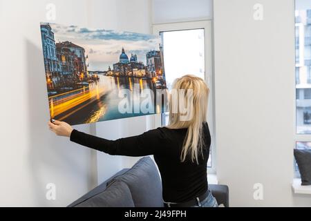 Fotoleinwand. Eine Frau, die eine Fotografie mit Gallery Wrap hält. Foto auf glänzendem Kunstleinwand gedruckt und auf Trageriegel gestreckt Stockfoto