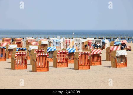 13. April 2022, Schleswig-Holstein, Travemünde: Gäste liegen in Strandliegen vor der Promenade von Travemünde und genießen die Sonne. Foto: Christian Charisius/dpa Stockfoto