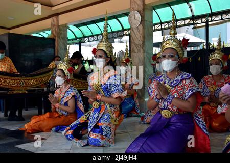 Bangkok, Thailand. 13. April 2022. Zum Auftakt des Songkran-Festivals treten Tänzer in einem Schrein in Bangkok mit schützenden Gesichtsmasken auf. In dieser Woche feiert Thailand sein erstes Songkran-Festival, eine Feier des neuen Jahres gemäß dem Sonnenkalender, seit Beginn der Pandemie, und während Wasserkämpfe verboten wurden, wurden öffentliche Veranstaltungen zum ersten Mal seit zwei Jahren zugelassen. Kredit: SOPA Images Limited/Alamy Live Nachrichten Stockfoto