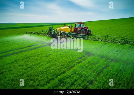 Luftaufnahme von landwirtschaftlichen Traktor Pflügen und Spritzen auf dem Feld. Stockfoto