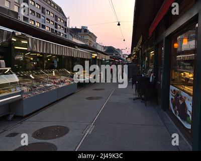 Abnehmende Perspektive des beliebten Marktes Naschmarkt in Wien, Österreich mit charakteristischen Ständen und Einkaufsbuden am Abend. Stockfoto