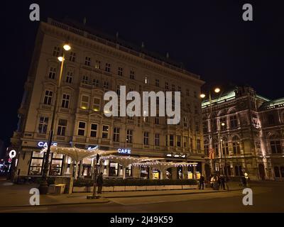 Nachtansicht des berühmten Luxushotels Sacher im historischen Zentrum von Wien, Österreich mit beleuchteter Fassade, Cafe Mozart und Wiener Oper. Stockfoto