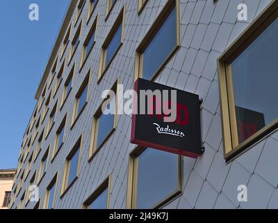 Flachwinkelansicht von Werbeschild und Logo an der Fassade des neuen Hotels Radisson Red Vienna in Österreich mit Reflexionen in den Fenstern an sonnigen Tagen. Stockfoto