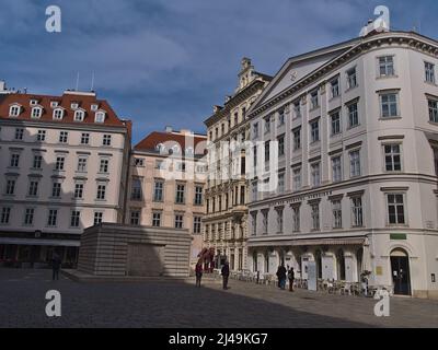 Blick auf den Judenplatz mit dem berühmten Holocaust-Mahnmal, umgeben von alten Gebäuden in Wien, Österreich, an einem sonnigen Frühlingstag mit Menschen. Stockfoto