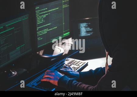 Hacker vor dem Computer. Blick von der Schulter. Hacker in der Haube Text eingeben Stockfoto