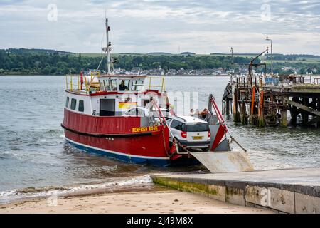 Fähre, die am Nigg Ferry Terminal ankommt, mit altem Balintraid Pier im Hintergrund – Nigg, Easter Ross Peninsula, Ross und Cromarty, Highland, Schottland, VEREINIGTES KÖNIGREICH Stockfoto