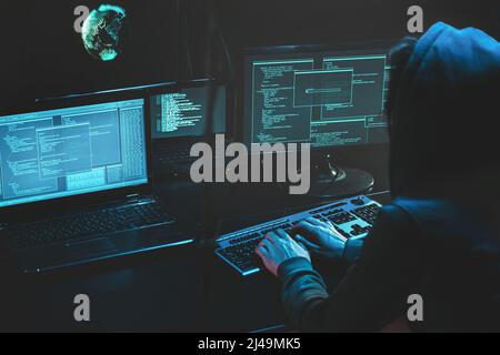 Cyber-kriminelle Hacking-System auf Monitoren, Hacker greifen Web-Server in dunklen Raum am Computer mit Monitoren senden Virus mit E-Mail-Schwachstelle Stockfoto