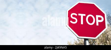 Stoppschild gegen einen strahlend blauen sonnigen Sommerhimmel. Mit Platz für Ihren Text. Nahaufnahme. Banner Stockfoto