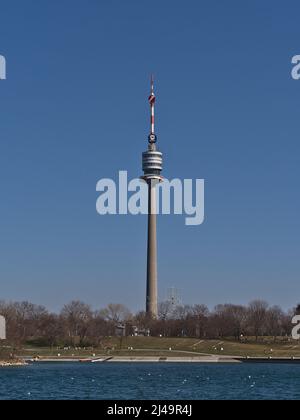 Schöne Aussicht auf den berühmten Donauturm in Wien, Österreich am Donauufer an sonnigen Frühlingstag von der Donauinsel aus gesehen. Stockfoto