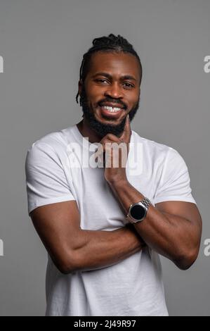 Fröhlicher Rüde mit seiner trendigen Uhr am Arm Stockfoto