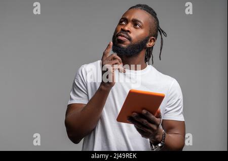 Nachdenklicher junger Mann, der an die Decke schaut Stockfoto
