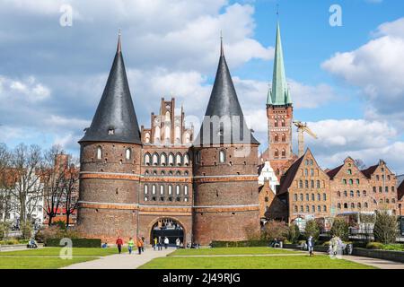 Lübeck, 11. April 2022: Holstentor oder Holstentor, berühmtes mittelalterliches Wahrzeichen in roter Backsteinarchitektur, Eingang zum historischen hanseatic CI Stockfoto