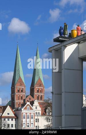 Marienkirche oder Marienkirche mit zwei Türmen und den als Fremde bezeichneten Skulpturen auf dem Dach der Musik- und Kongresshalle (MuK) in Lübeck, Germ Stockfoto