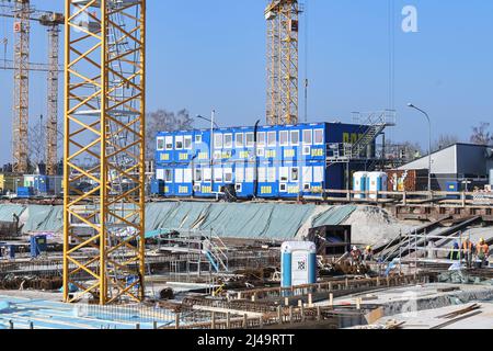 Lübeck, 3. März 2022: Blauer Bürocontainer auf einer großen Baustelle mit Fundamenten, Verstärkungen und Kränen für einen Neubau Stockfoto