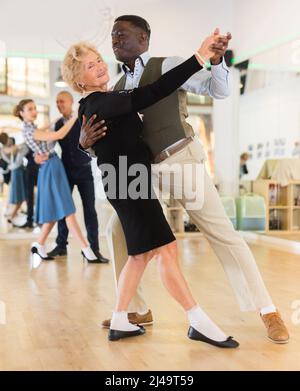 Mann und ältere Frau tanzen Walzer im Studio Stockfoto