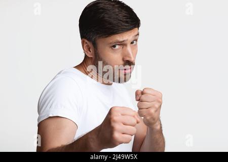 Entschlossener Mann, Der Fäuste Zusammenhält, Bereit, Um Über Weißen Hintergrund Zu Kämpfen Stockfoto