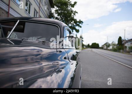 Altes amerikanisches Auto, das auf der Seite der isolierten Straße geparkt wurde Stockfoto