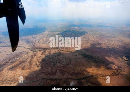 Blick auf die Thar-Wüste aus einem Flugzeug, Rajasthan, Indien. Die Propeller und Thar Wüste im Rahmen.Spiel von Sonnenlicht und Wolken Schatten auf der Wüste Stockfoto