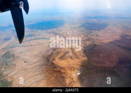 Blick auf die Thar-Wüste aus einem Flugzeug, Rajasthan, Indien. Die Propeller und Thar wüsten im Rahmen. Spiel von Sonnenlicht und Wolken Schatten auf dem Deser Stockfoto