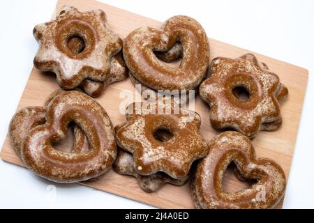 Lebkuchenkekse hart und sternförmig auf Holzbrett Stockfoto