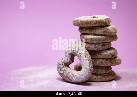 Gestapelte herzförmige Lebkuchen auf purpurem Hintergrund Stockfoto
