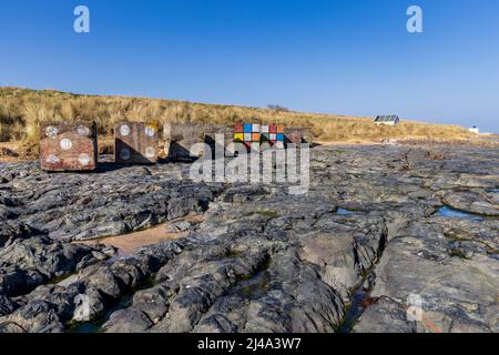 Bemalte Panzerabwehrwürfel aus dem Zweiten Weltkrieg am Bamburgh Beach, Northumberland Coast Path, England Stockfoto