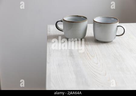 Zwei hellblaue Porzellanbecher stehen auf dem Tisch Stockfoto