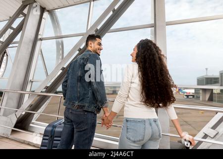 Romantische Ehegatten aus dem Nahen Osten warten auf den gemeinsamen Flug am Flughafen, im niedrigen Winkel Stockfoto