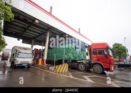 (220413) -- HANGZHOU, 13. April 2022 (Xinhua) -- Güterkraftwagen fahren am 13. April 2022 in Hangzhou, der ostchinesischen Provinz Zhejiang, in den Hangzhou Transfar Highway-Hafen ein. Der Hangzhou Transfar Highway Port liegt im Qiantang District in Hangzhou und bedient insgesamt über 280 Logistikunternehmen, wobei täglich mehr als 7.000 Fahrzeuge den Hafen betreten und verlassen. Der Hafen ist einer der wichtigsten Logistikzentren der Stadt. Die Mitarbeiter des Autobahnhafens, die Mitarbeiter der Logistikunternehmen und die Lkw-Fahrer haben hart daran gearbeitet, die Versorgung von Haushalten und Industrie zu erleichtern Stockfoto