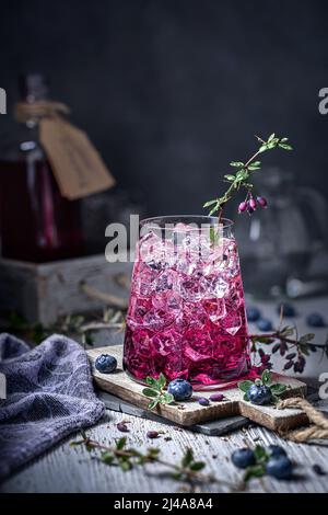 Heidelbeergetränk mit Eis in einem schönen Glas mit Beeren verziert. Ein erfrischendes Getränk im Sommer. Stockfoto