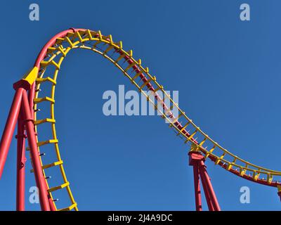 Nahaufnahme der rot-gelben Schienen einer Achterbahn im beliebten Freizeitpark Wurstelprater in Wien, Österreich, an sonnigen Tagen. Stockfoto