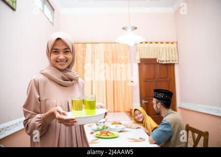 muslimische Mutter serviert etwas Essen für das Familienessen Stockfoto