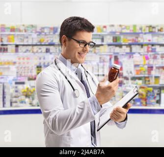 Apotheker beim Betrachen einer Flasche Pillen in einer Apotheke Stockfoto