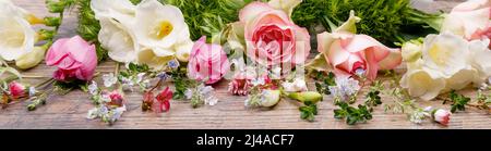 Frühling oder Sommer Komposition aus schönen Blumen, Kräutern und Beeren auf Holzkulisse. Floristische Dekoration. Stockfoto