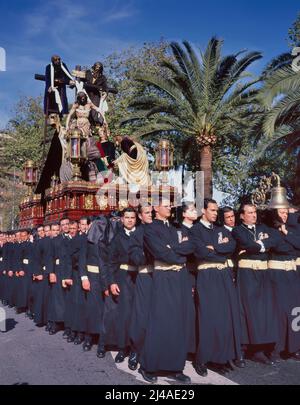 MALAGA, SPANIEN-APRIL,08 2012: Eine Gruppe von Trägern (Costaleros genannt), die einen religiösen Festwagen (bekannt als Tronos) in den Prozessionen trugen, die zum Feiern abgehalten wurden Stockfoto