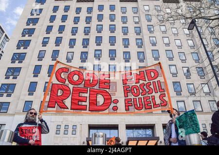 London, England, Großbritannien. 13. April 2022. Die Demonstranten halten vor dem Shell-Hauptquartier ein Transparent mit der Aufschrift „Code Red: End Fossil Fuels“. Aktivisten des Extinction Rebellion verursachten Chaos im Londoner Hauptquartier des Ölgiganten Shell, wobei sich Dutzende von Demonstranten vor dem Eingang am Boden und mehrere im Gebäude klebten. (Bild: © Vuk Valcic/ZUMA Press Wire) Stockfoto