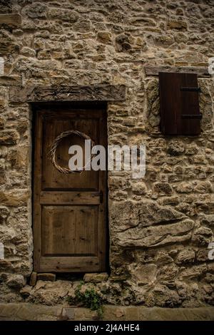 Eine alte Holztür in Poffabro, einem historischen mittelalterlichen Dorf im Val Colvera Tal in der Provinz Pordenone, Friaul-Julisch Venetien, Nordostitalien Stockfoto