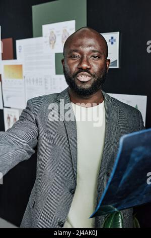 Porträt eines afrikanischen männlichen Radiologen, der im Büro mit Röntgenbildern arbeitet Stockfoto