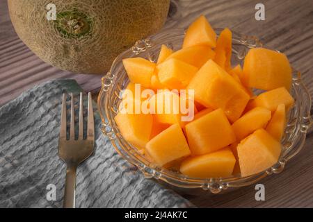 In Würfel geschnittene Muskmelonenfrüchte, die reich an Vitaminen und Mineralstoffen sind. Draufsicht auf eine Schüssel mit Moschusmelonenfrüchten. Stockfoto