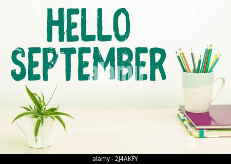 Schild zeigt Hallo September an. Konzept bedeutet, dass wir uns sehr herzlich für den Monat September Tidy Workspace Setup, Writing Desk Tools begrüßen möchten Stockfoto