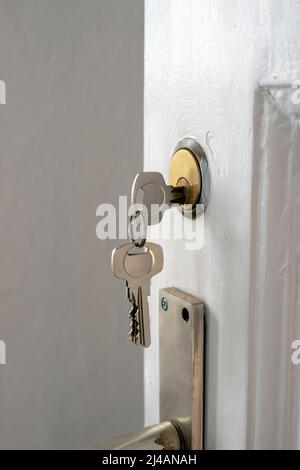 Fragment der offenen Tür mit Schlüsseln im Schlüsselloch Stockfoto