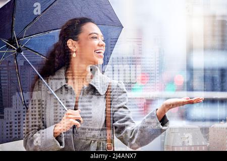 Man kann keine Blumen haben, ohne ein wenig Regen zu haben. Aufnahme einer jungen Geschäftsfrau, die einen Regenschirm vor der Tür trägt. Stockfoto