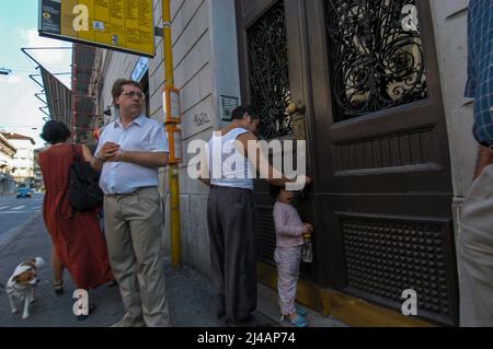 Triest, Italien 01/09/2005: padre con figlia cinesi e persone ad una fermata dell'Autobus - chinesischer Vater und Tochter beim Betreten der Wohnung. ©Andrea Sabbadini Stockfoto