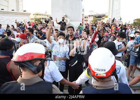 Bangkok, Thailand. 13. April 2022. Regierungsfeindliche Demonstranten halten drei Finger am Demokratie-Denkmal. Ratchadamnoen Road, Bangkok, Thailand, mit der Polizei, die die Menge kontrolliert. Um Unruhen am 13. April 2022 zu verhindern. (Foto von Teera Noisakran/Pacific Press/Sipa USA) Quelle: SIPA USA/Alamy Live News Stockfoto