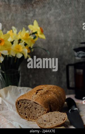 Laib frisches Brot und Backzutaten für selbstgebackenes Backen auf Holztisch. Baker Food Set auf Holz Plank Board Hintergrund Textur mit Copy Space. Stockfoto