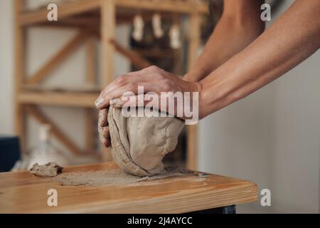 Nicht erkennbarer Potter Master bereitet Tonstapel auf die Herstellung von Topf auf einem Töpferrad im Keramikstudio vor Stockfoto