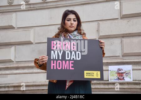 London, Großbritannien. 13. April 2022. Roxanne Tahbaz hält während des Protestes ein Plakat mit dem Titel „Bring My Dad Home“. Roxanne Tahbaz veranstaltete einen Protest mit Amnesty International vor dem Außen-, Commonwealth- und Entwicklungsbüro in Westminster und forderte die britische Regierung auf, ihre Bemühungen zu verstärken, ihren Vater Morad Tahbaz nach Hause zu holen. Morad, ein Naturschützer und US- und britischer Staatsbürger mit iranischem Familienhintergrund, ist seit mehr als vier Jahren willkürlich im Iran inhaftiert. Kredit: SOPA Images Limited/Alamy Live Nachrichten Stockfoto